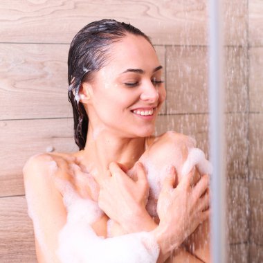 Genç beautyful kadın banyoda duş altında.