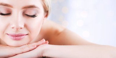 Gözleri kapalı rahatlatıcı bir masaj masanın üzerinde yatan genç kadın