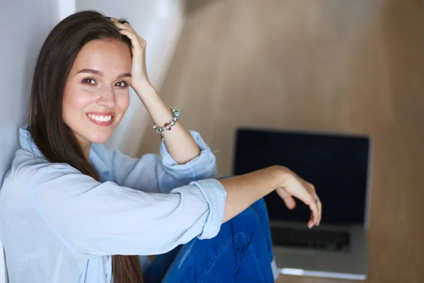 年轻漂亮的女人在家里坐在用笔记本电脑在地板上。年轻漂亮的女人. — 图库照片