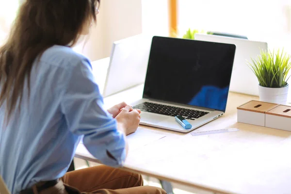 Jovem sentada à mesa do escritório com laptop. Jovem. Laptop — Fotografia de Stock