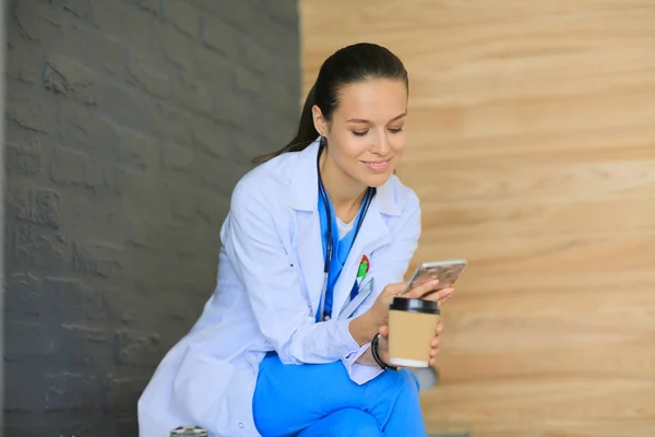 Een jonge vrouwelijke dokter die bij je telefoon zit. Vrouwelijke artsen. — Stockfoto