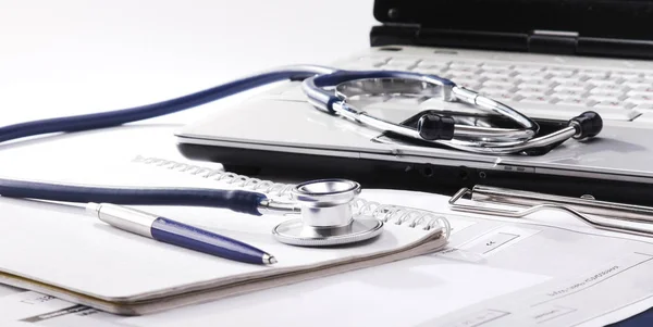 Estetoscópio com área de transferência e laptop na mesa — Fotografia de Stock