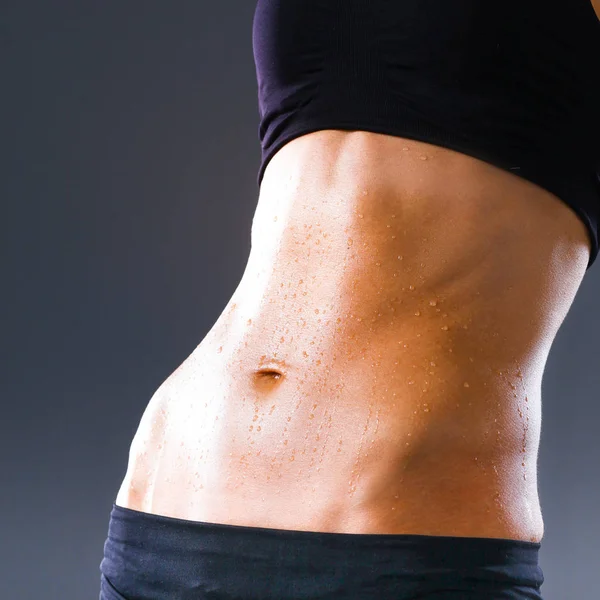 Musclé jeune femme debout sur fond gris — Photo