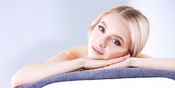 Young woman lying on a massage table,relaxing with eyes closed — Stock Photo, Image