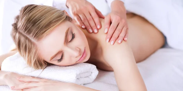 Ung kvinna liggande på en massagebänk, avkopplande med slutna ögon — Stockfoto