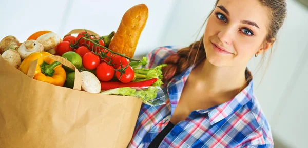 Νεαρή γυναίκα κρατώντας τσάντα ψώνια με λαχανικά — Φωτογραφία Αρχείου