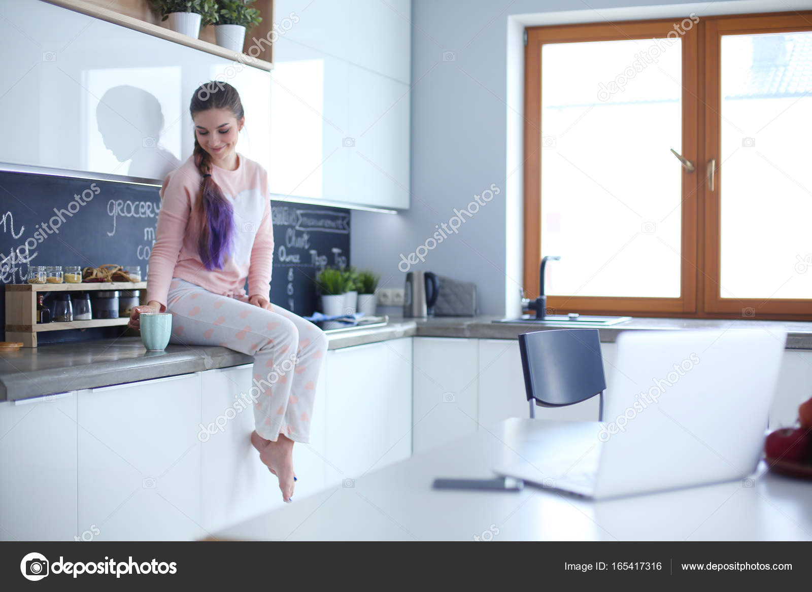 Joven mujer sentada en la mesa en la cocina — Fotos de Stock ... Joven mujer sentada en la mesa en la cocina — Fotos de Stock ...