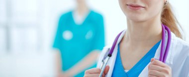 Kadın doktor hastanede dosyayla bekliyor.