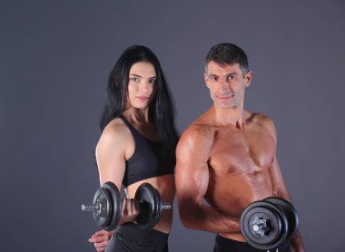 Atletik erkek ve kadın salak-bells ile. Kişisel fitness eğitmeni. Kişisel eğitim. Ağırlık çalışması. Egzersiz.