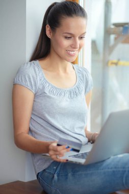 Evde bir dizüstü bilgisayar kullanan genç güzel kadın. Genç güzel kadın.