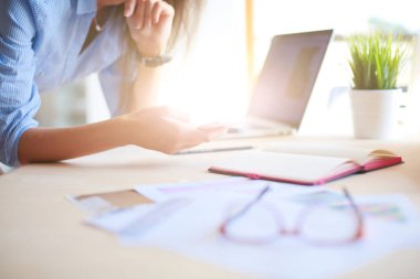 Ofis masasında oturan ve cep telefonuyla konuşan genç ve güzel bir iş kadını. İş kadını