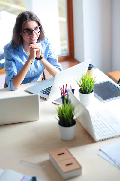 Giovane donna seduta al tavolo dell'ufficio con computer portatile. Giovane donna. Portatile — Foto Stock