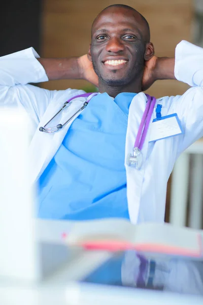 Un joven médico africano trabajando en un portátil en el escritorio. ¿Doctor? Lugar de trabajo — Foto de Stock