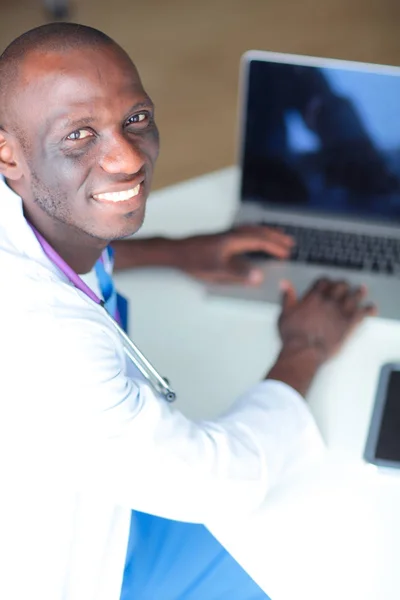 Klinikteki masada bilgisayar kullanırken kulaklık takan genç bir doktorun portresi. Doktor.. — Stok fotoğraf