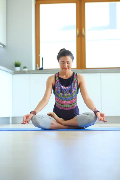 Mujer joven haciendo yoga en casa en la posición de loto. Yoga. Una mujer. Estilo de vida — Foto de Stock