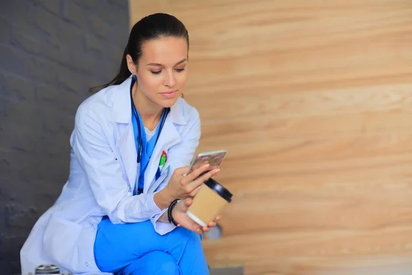 Een jonge vrouwelijke dokter die bij je telefoon zit. Vrouwelijke artsen. — Stockfoto