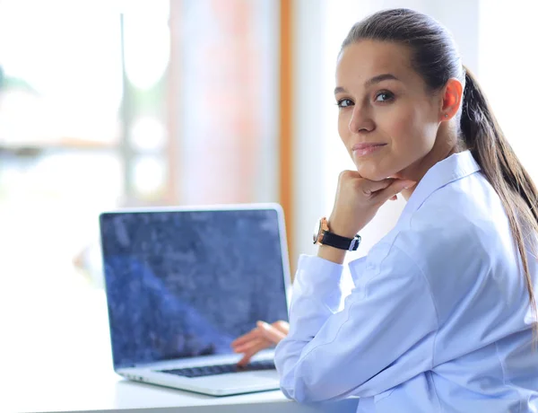 Vacker ung leende kvinnlig läkare sitter vid skrivbordet. Kvinnlig läkare — Stockfoto
