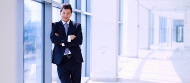 Ofisteki pencerenin yanında duran işadamının portresi