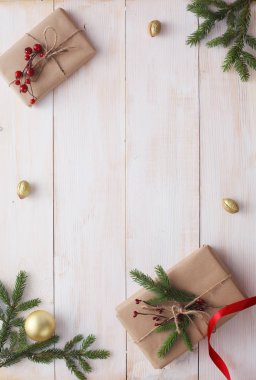 Noel hediye kutuları ve köknar ağacı dalı ahşap masa üzerinde düz yatıyordu