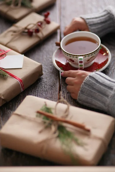 Femme assise sur le bureau avec boîte cadeau de Noël — Photo