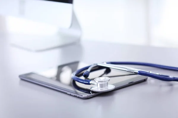 Медицинское оборудование: синий стетоскоп и таблетки на белом фоне — стоковое фото