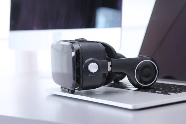Virtual reality goggles on desk with laptop — Stock Photo, Image