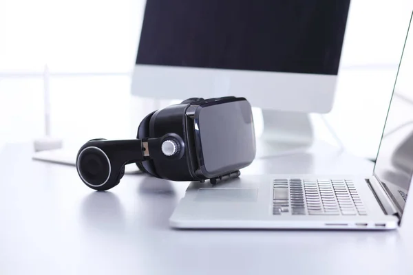 Virtual reality goggles on desk with laptop — Stock Photo, Image