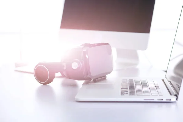 Virtual reality goggles on desk with laptop — Stock Photo, Image