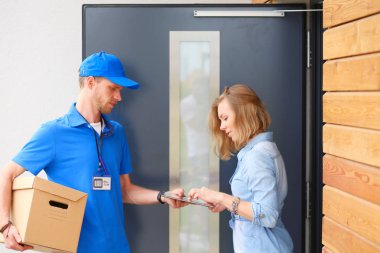 Mavi üniformalı gülümseyen kurye servis konseptine paket kutusu teslim eden teslimatçı. Mavi üniformalı gülümseyen teslimatçı.