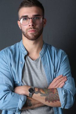 Mutlu bir casual adam ayakta karanlık bir arka plan üzerinde izole portresi. Yakışıklı erkek poz.