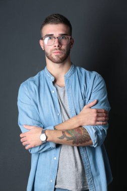 Mutlu bir casual adam ayakta karanlık bir arka plan üzerinde izole portresi. Yakışıklı erkek poz.