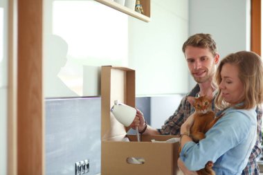 Genç bir çift yeni evde büyük karton kutu taşıyan. Ev taşıma. Genç Çift