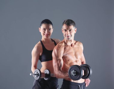Atletik erkek ve kadın ile bir dumbells. Kişisel fitness eğitmeni. Kişisel eğitim.