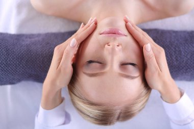 Masaj masasında uzanmış gözleri kapalı rahatlayan genç bir kadın. - Kadın. Spa salonu