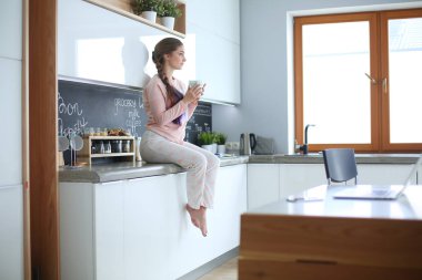 Mutfakta masada oturan genç kadın.