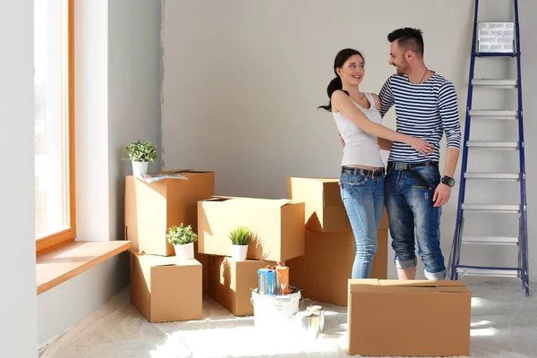 Açma veya kutu ambalaj ve yeni evine taşıdıktan mutlu genç bir çift. Genç Çift