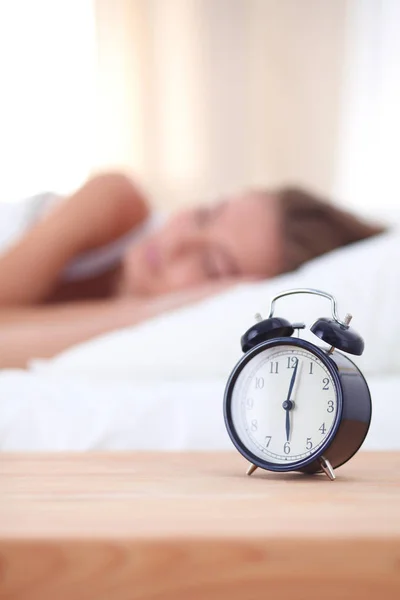 Young sleeping woman and alarm clock in bedroom at home. Young sleeping woman. — Stock Photo, Image
