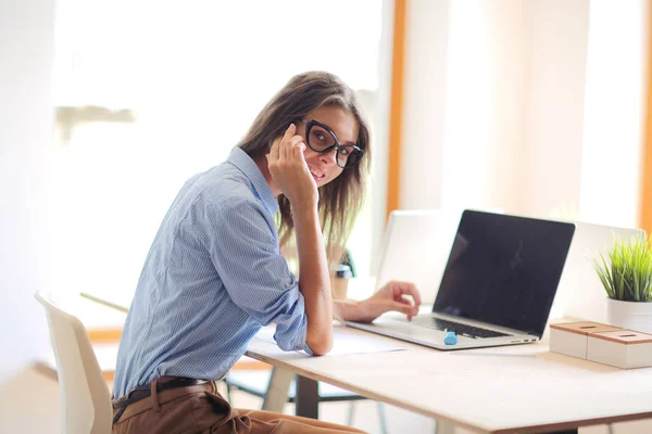 Mujer joven sentada en la mesa de la oficina con portátil. Jovencita. Ordenador portátil — Foto de Stock