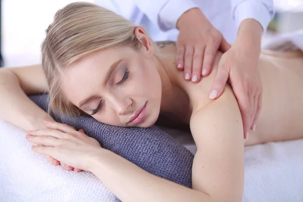 Mujer joven acostada en una mesa de masaje, relajándose con los ojos cerrados. Una mujer. Salón de spa —  Fotos de Stock