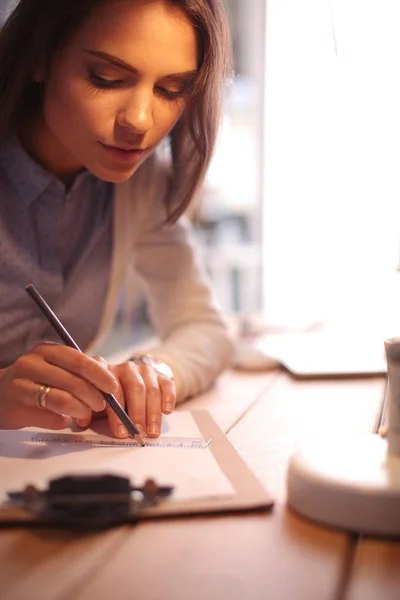 Une jeune femme travaillant assise à un bureau. Femme d'affaires. Dessin. Étudiant. En milieu de travail. Bureau. — Photo