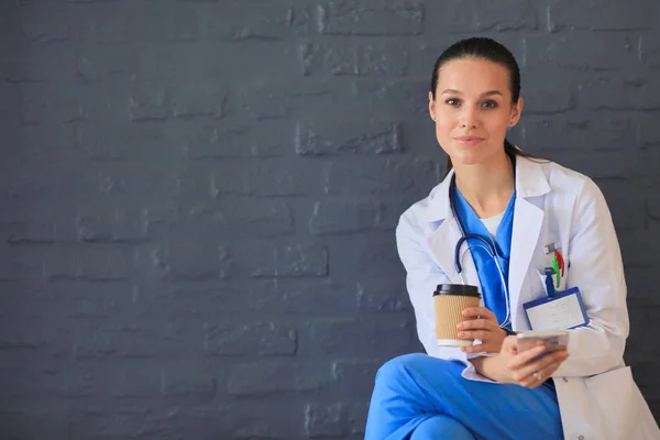 Een jonge vrouwelijke dokter die bij je telefoon zit. Vrouwelijke artsen. — Stockfoto