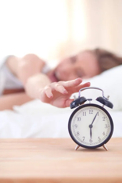 Young sleeping woman and alarm clock in bedroom at home. Young sleeping woman. Stock Photo