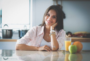 Mutfakta masada oturan genç bir kadın.