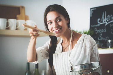Mutfakta ahşap kaşıkla yemek pişiren kadın