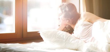 Güzel bir kadın yatağında uzanıyor.