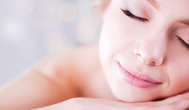 Gözleri kapalı rahatlatıcı bir masaj masanın üzerinde yatan genç kadın