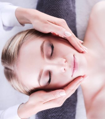 Gözleri kapalı rahatlatıcı bir masaj masanın üzerinde yatan genç kadın