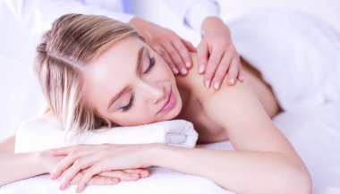 Gözleri kapalı rahatlatıcı bir masaj masanın üzerinde yatan genç kadın