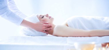 Gözleri kapalı rahatlatıcı bir masaj masanın üzerinde yatan genç kadın