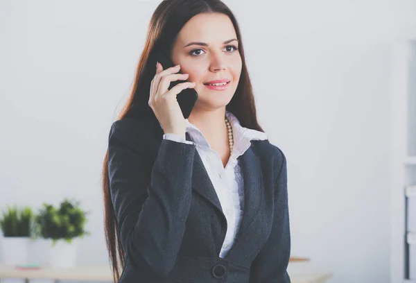 Uma bela mulher de sucesso falando ao telefone no escritório moderno — Fotografia de Stock